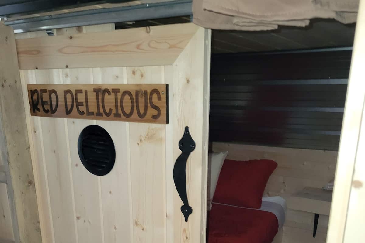 Een houten deur met een bord waarop staat 'RED DELICIOUS'.