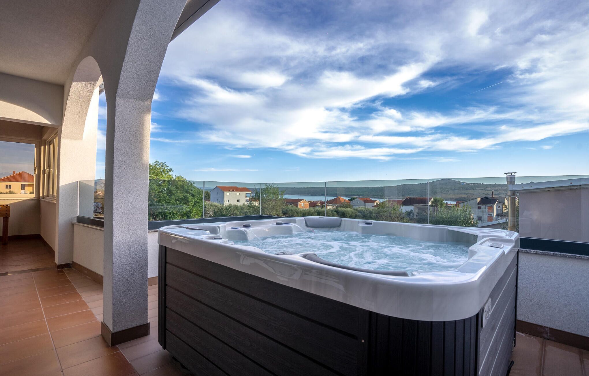 A hot tub on a balcony with a clear view of the surrounding landscape.