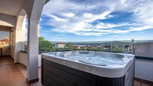 Una vasca idromassaggio su un balcone con vista panoramica sul paesaggio circostante.