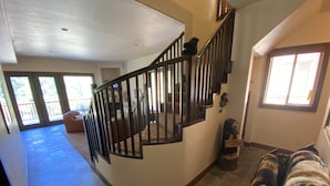 Un espacio habitable amplio con una escalera curva, un ventanal y vistas al exterior.