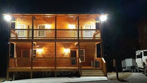A two-story wooden cabin with a balcony, a front porch, and a truck parked outside. - Mountain Porches at Blackberry Ridge  (Near everything) (Pigeon Forge)