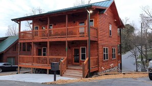 A two-story log cabin with a balcony on the upper floor, a front porch, and a mailbox. - Mountain Porches at Blackberry Ridge  (Near everything) (Pigeon Forge)