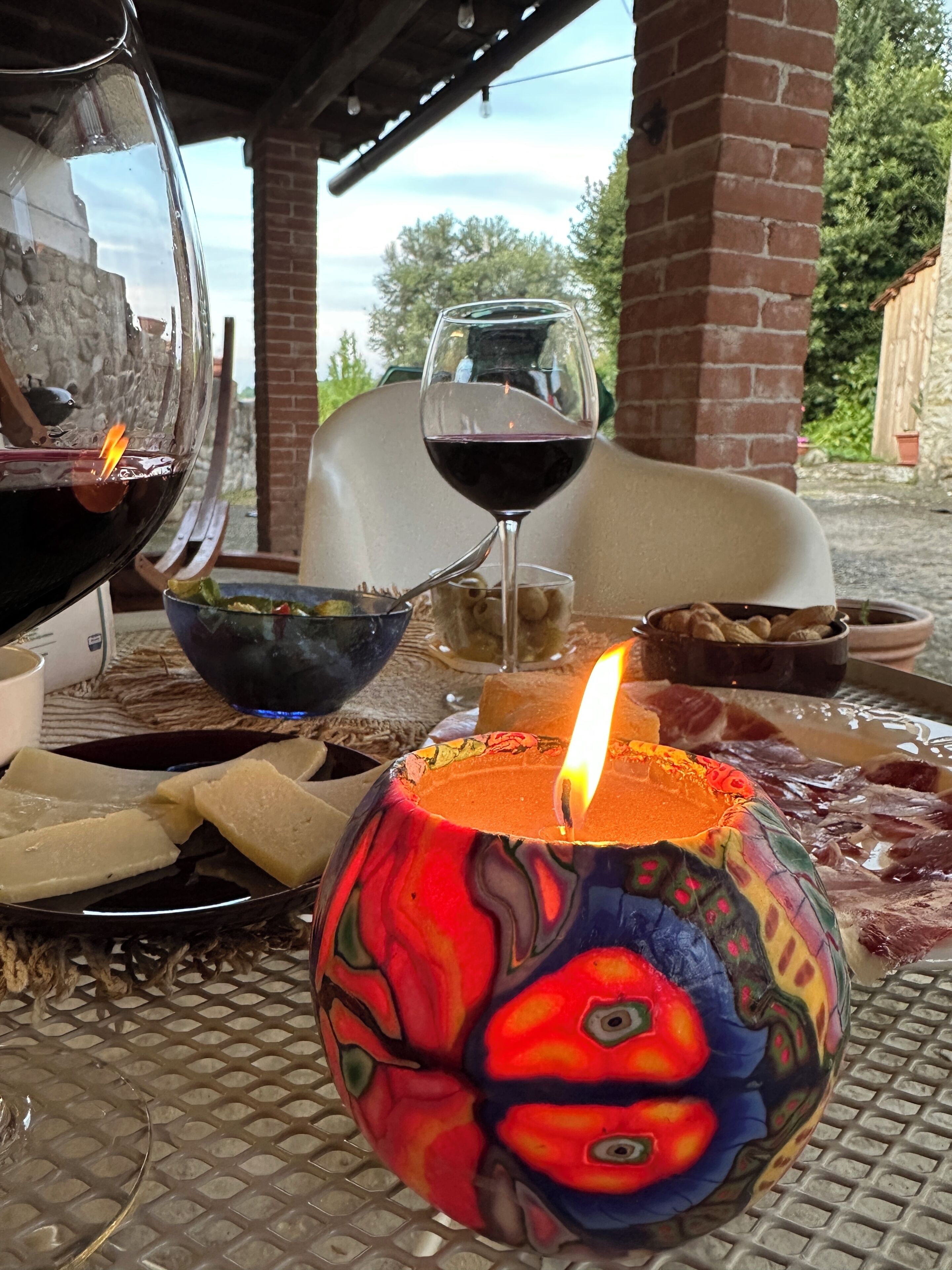 Ein Tisch mit einer Kerze, einem Weinglas und einer Schüssel Essen.