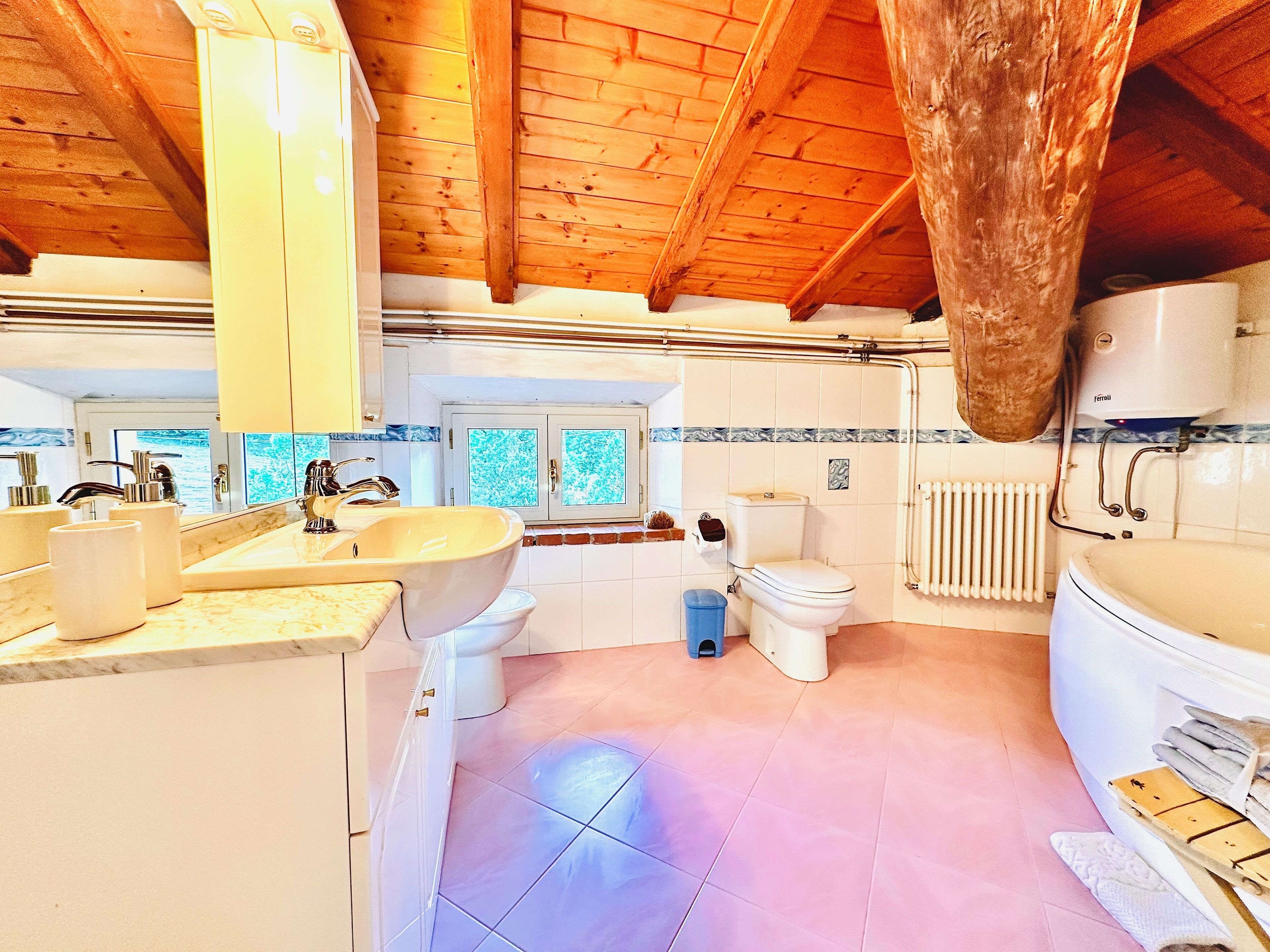Une salle de bain moderne avec un plafond en bois, un lavabo, des toilettes et une baignoire.
