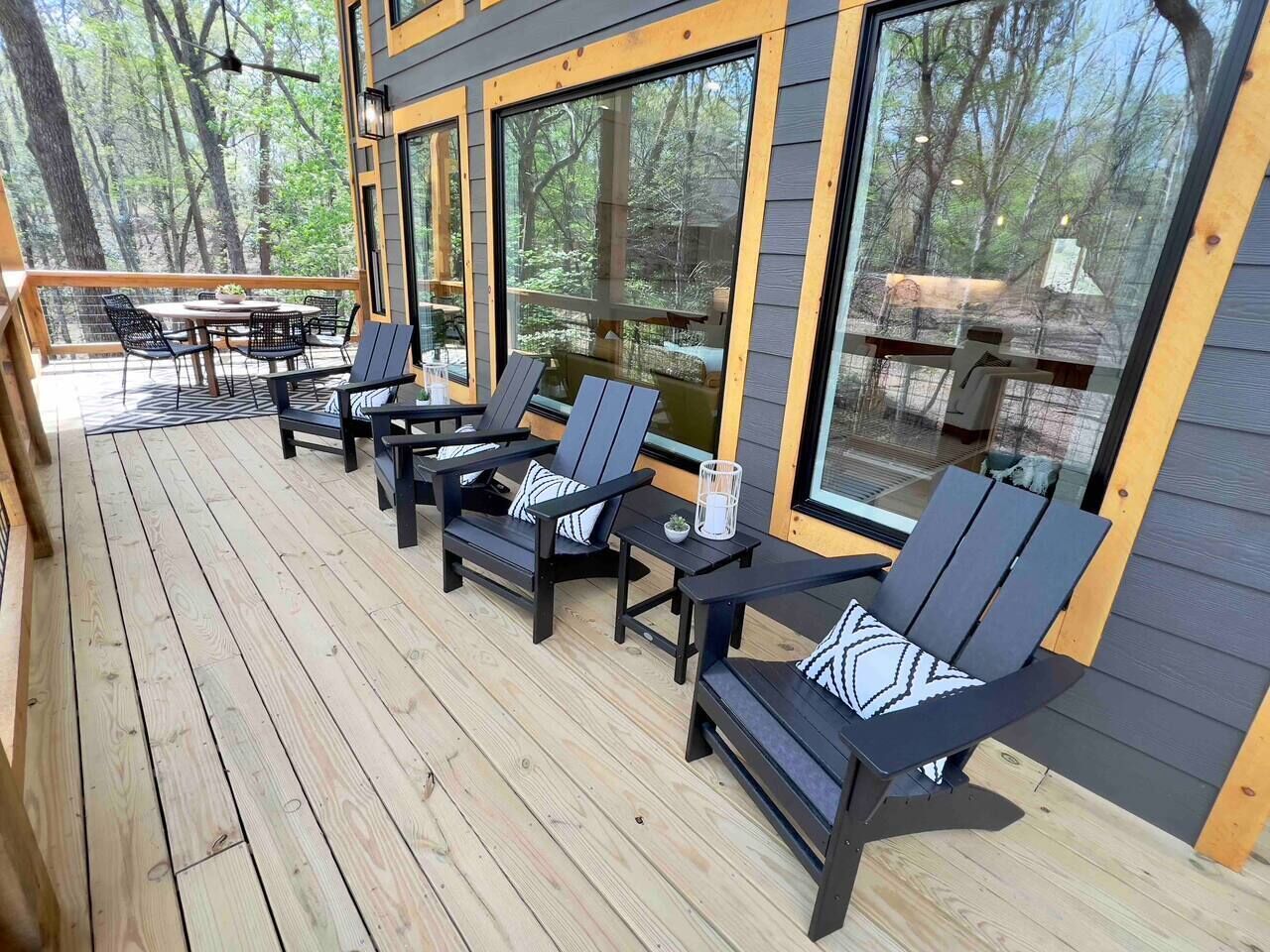 A deck with outdoor seating and large windows.