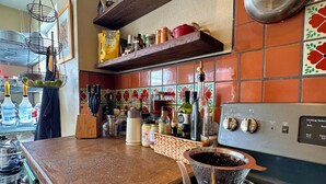 Une cuisine équipée d’une cuisinière, d’une bouilloire et de divers ustensiles de cuisine.
