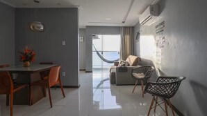 Ein modernes Wohnzimmer mit Essbereich, einer Couch und einer Hängematte.