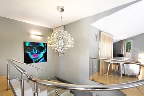 Ein modernes Interieur mit Treppe, einer Kronleuchter und einem Essbereich.