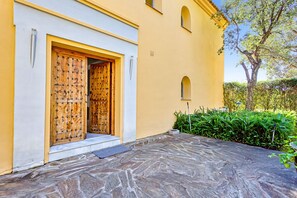 A building with a wooden door, a stone-paved entrance, and a small window. - Luxury Villa with spectaculair views Varenso Holidays (Marbella)