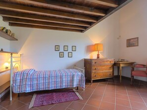 Une chambre à coucher avec un lit, une commode, un bureau et une chaise.