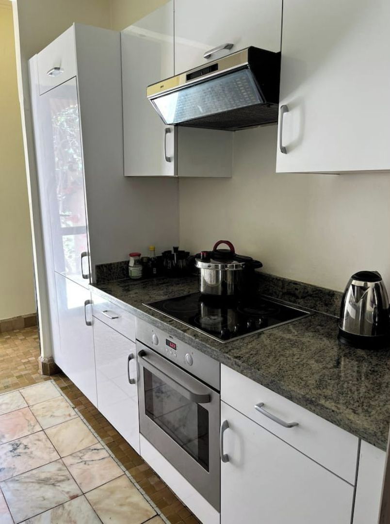 A modern kitchen with white cabinets, a built-in stove, oven, and a microwave.