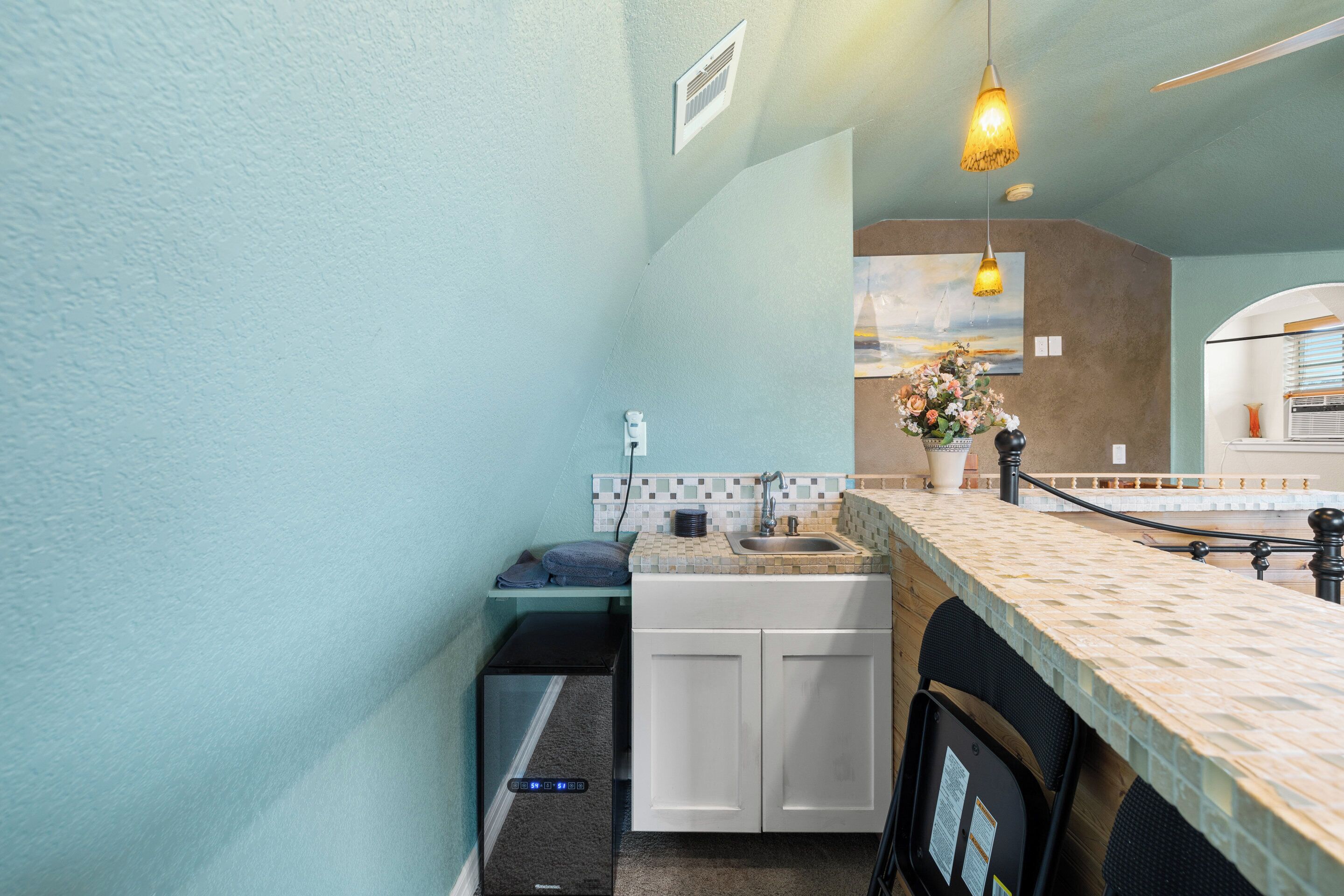 A compact kitchen with a tiled backsplash, a sink, and a countertop.