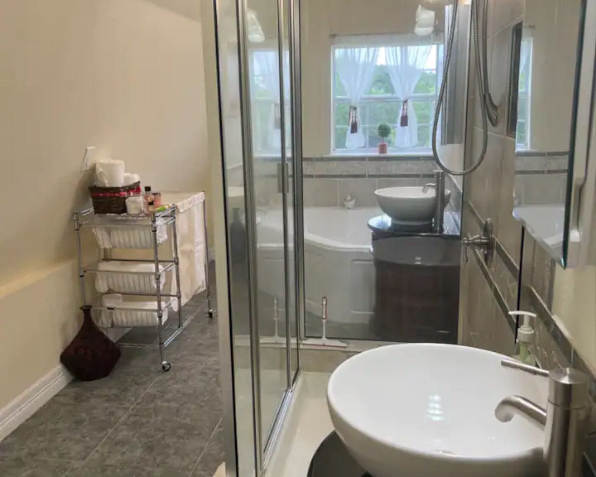 Un baño moderno con cabina de ducha de vidrio, un lavabo blanco y una bañera.