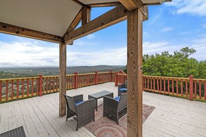 A wooden deck with outdoor furniture and a view of the landscape. - Hilltop/2Kingbeds/Wi-Fi/Sleeps7/Jacuzzi/TerraceDine/Entire2br2baHome/4acres/Pets (Marble Falls)