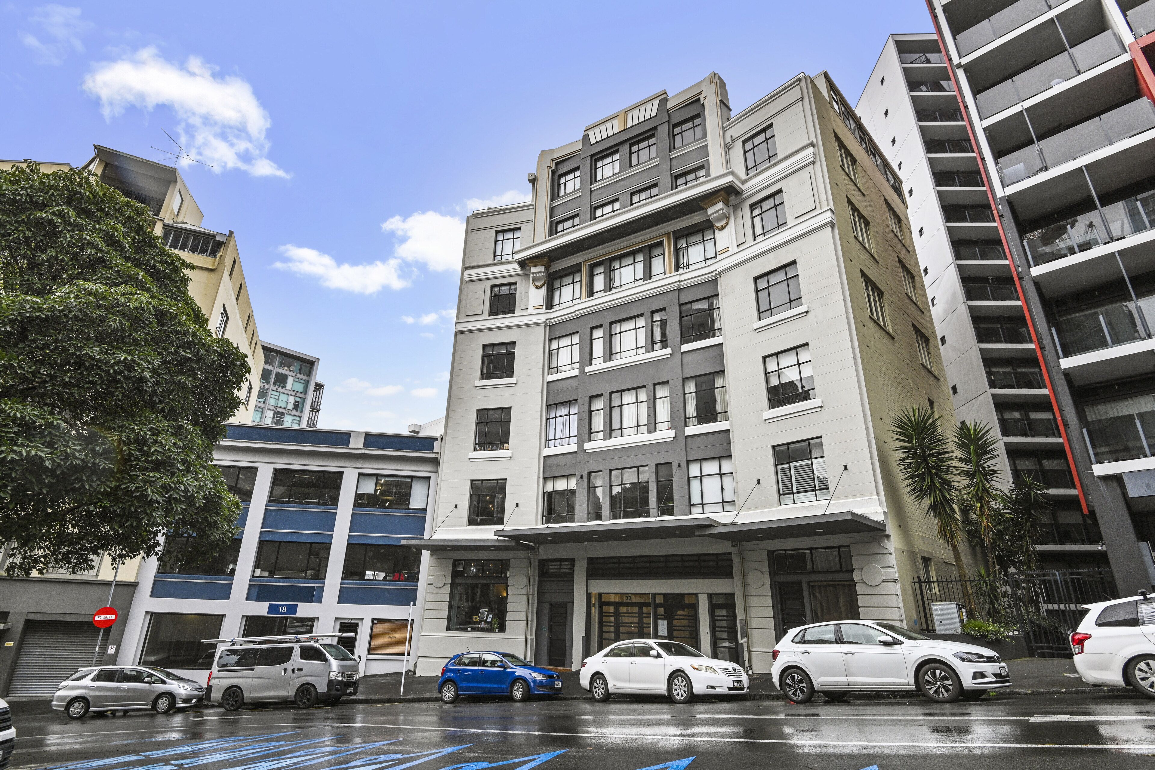 A multi-story building with a modern architectural design, featuring a mix of residential and commercial spaces.