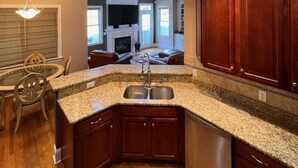 A modern kitchen with granite countertops, wooden cabinets, and a built-in dishwasher. - Executive Home on over an Acre of Land.  Country Living at its Best. (Youngsville)