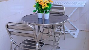 A round metal table with two white pots of artificial flowers. - Résidence Clean (Abidjan)