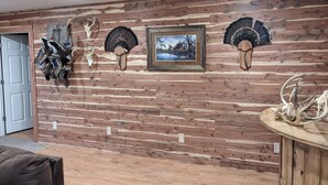 Ein Zimmer mit einer Holzwand, einem gerahmten Bild und montierten Tierkopfpräparaten.