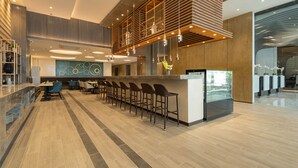 A modern hotel lobby with a central bar area, seating, and a decorative wall. - Bayfront Hotel Cebu - Capitol Site (Cebu City)