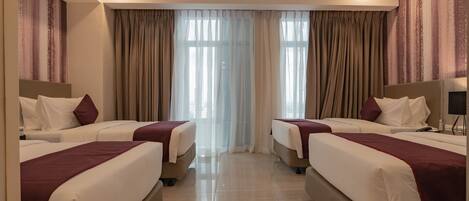 Una habitación de hotel con dos camas, un ventanal grande con cortinas y un diseño moderno.