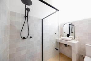A modern bathroom with a glass shower enclosure, a white sink with a mirror, and a toilet. - THE BERRY VIEW (Berry)