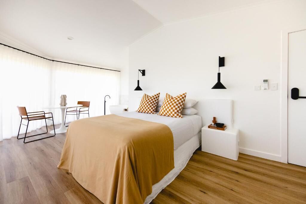 Une chambre d’hôtel moderne avec un grand lit, un petit bureau et une chaise.