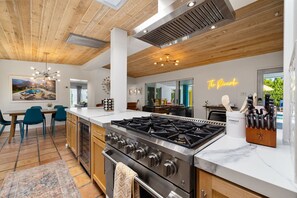 Enjoy cooking in this well-equipped kitchen with a central island, stainless steel stove, and ample counter space.