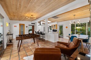 Relax in this spacious living area with a foosball table, leather chairs, and a dining table.