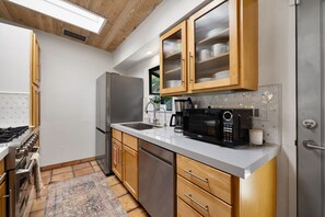 Enjoy cooking in this well-equipped kitchen with a refrigerator, dishwasher, and microwave, plus ample storage and a large window.