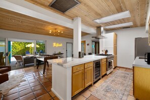 Enjoy meals in the kitchen with a central island, dining area, and large windows offering a view of the outdoors.
