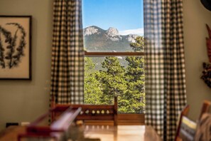 A room with a view of mountains through checkered curtains. - Arapaho Forest Lodge | Hot Tub, Game Room, Dogs (Black Hawk)
