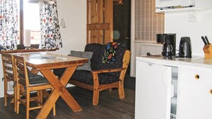 A compact kitchen with a refrigerator, coffee maker, and knife block. - Nice Home in Transtrand With Sauna and Wifi (Transtrand)