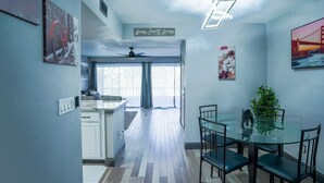 Una cocina moderna con comedor, ventilador de techo y vista al exterior.