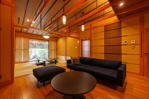 A traditional Japanese room with tatami flooring, a low table, a sofa, and sliding doors. - yado-shiontei (Yonago)