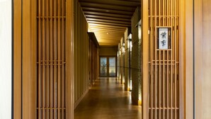 A corridor with wooden paneling and a sign with Japanese characters. - yado-shiontei (Yonago)