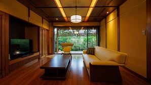 A modern living room with a sofa, coffee table, and TV. - yado-shiontei (Yonago)