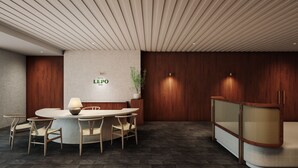 A modern hotel lobby with a round table, chairs, a sofa, and a reception desk. - HOTEL LEPO CHAHAL (Matsuyama)
