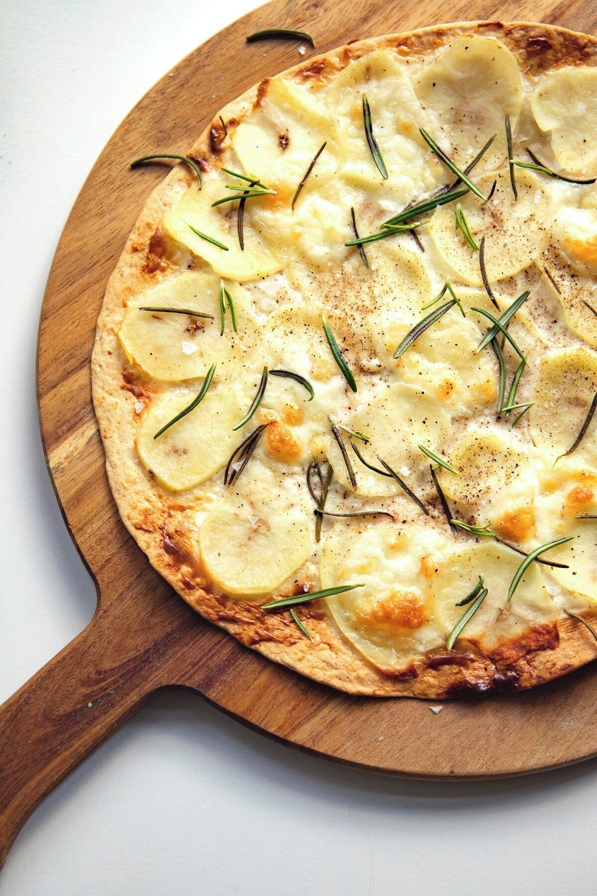 Een pizza op een houten plank.
