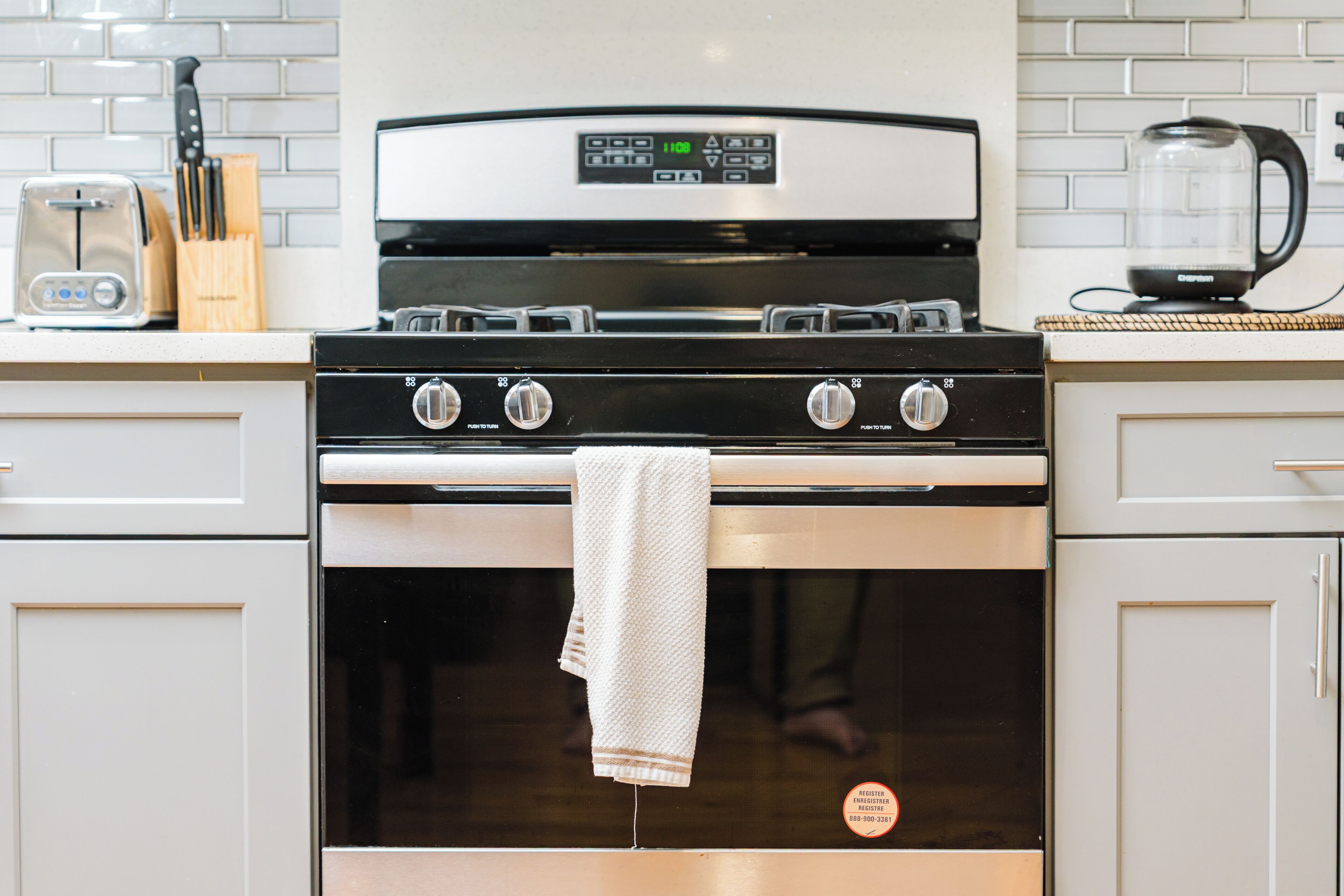 A kitchen with a stove, oven, and a coffee maker on the counter.