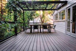 Back deck directly off of the kitchen. Enjoy a family meal under the abundant grape canopy and twinkling lights