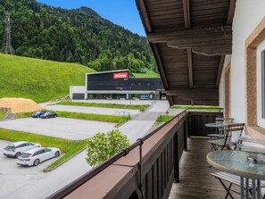 Un hotel con balcone, parcheggio e un edificio con insegna di comprensorio sciistico.