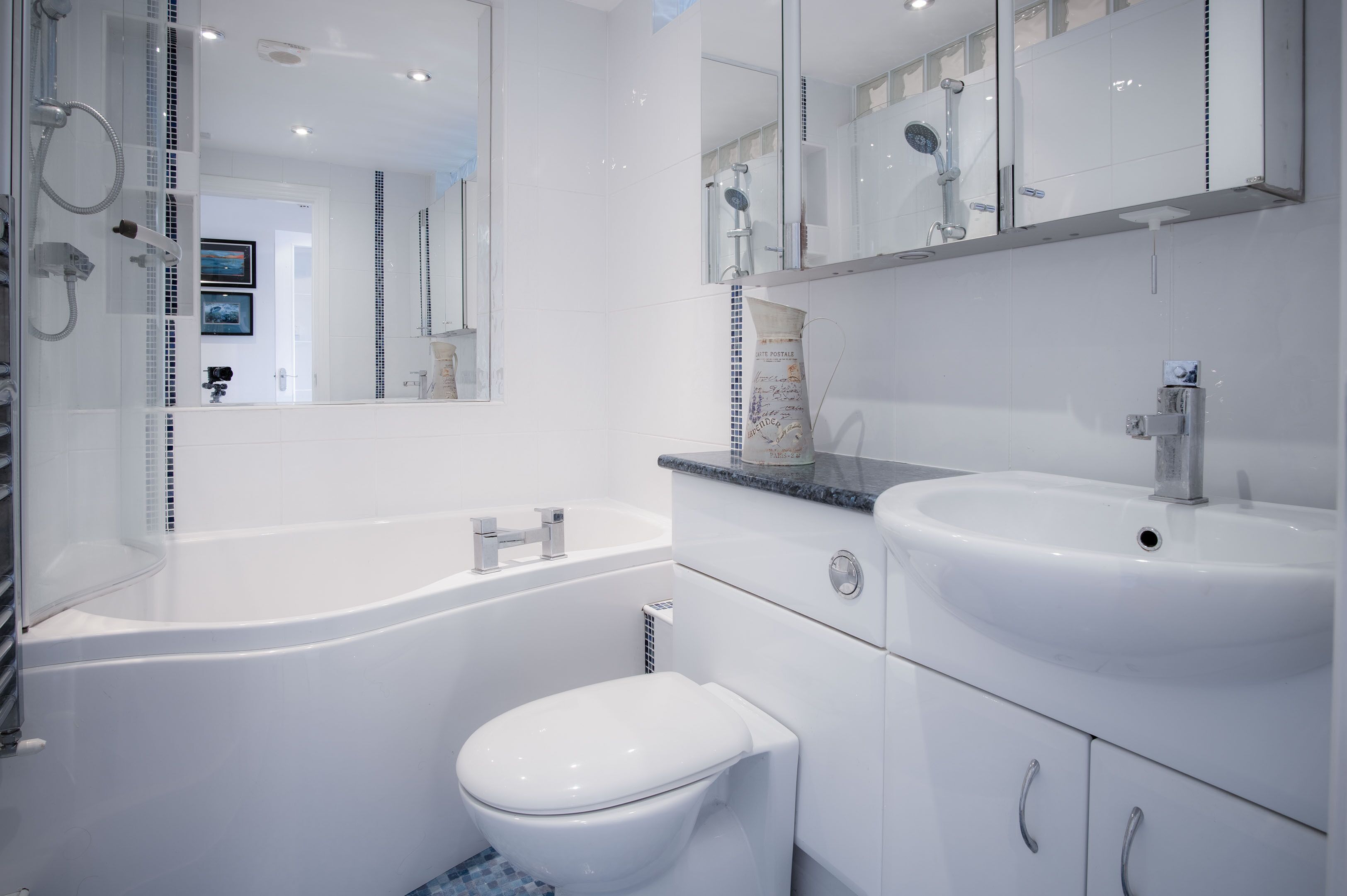 A modern bathroom with a white bathtub, a sink, and a toilet.