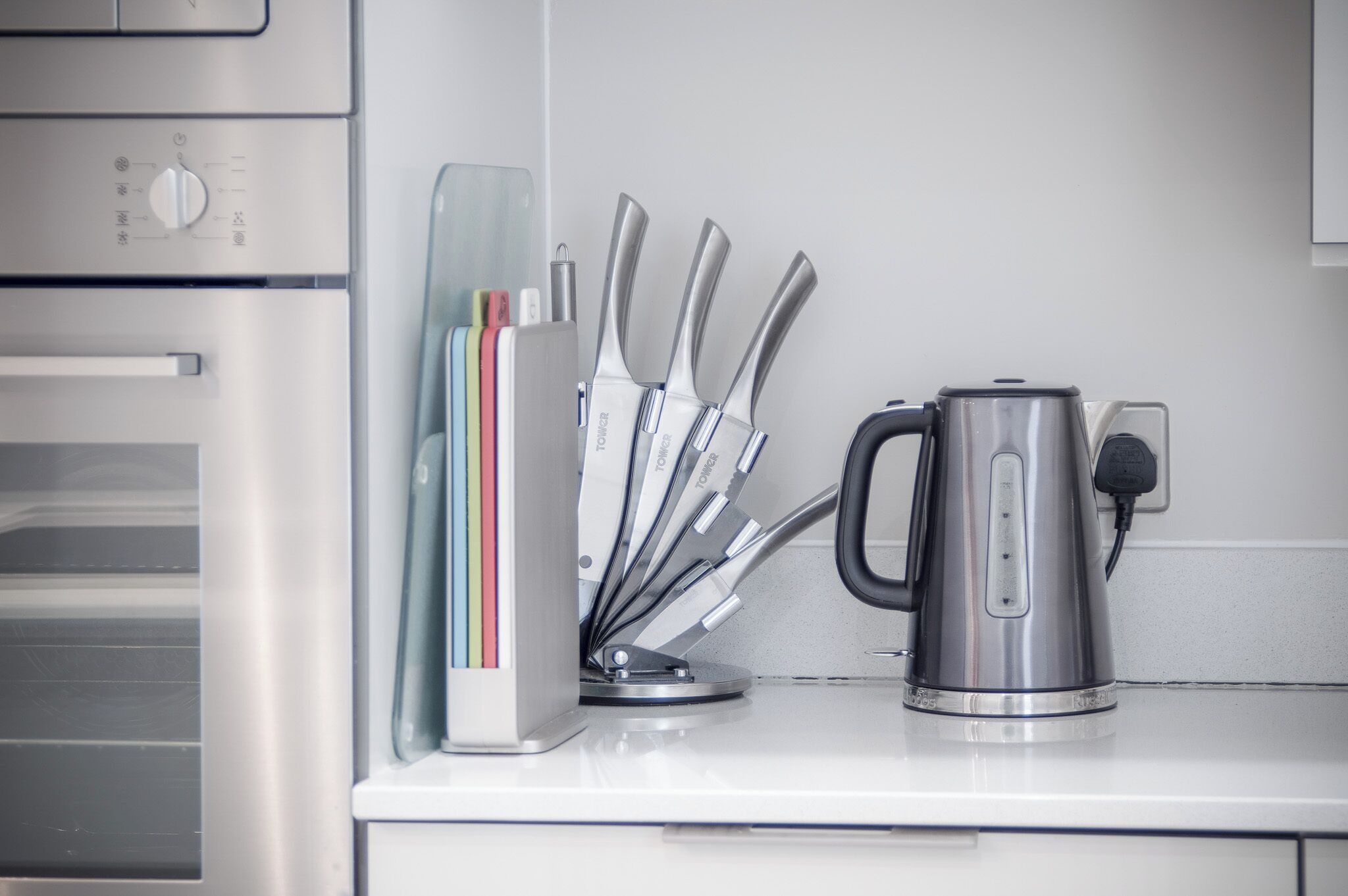 A kitchen counter with a coffee maker, a knife block, and a microwave.