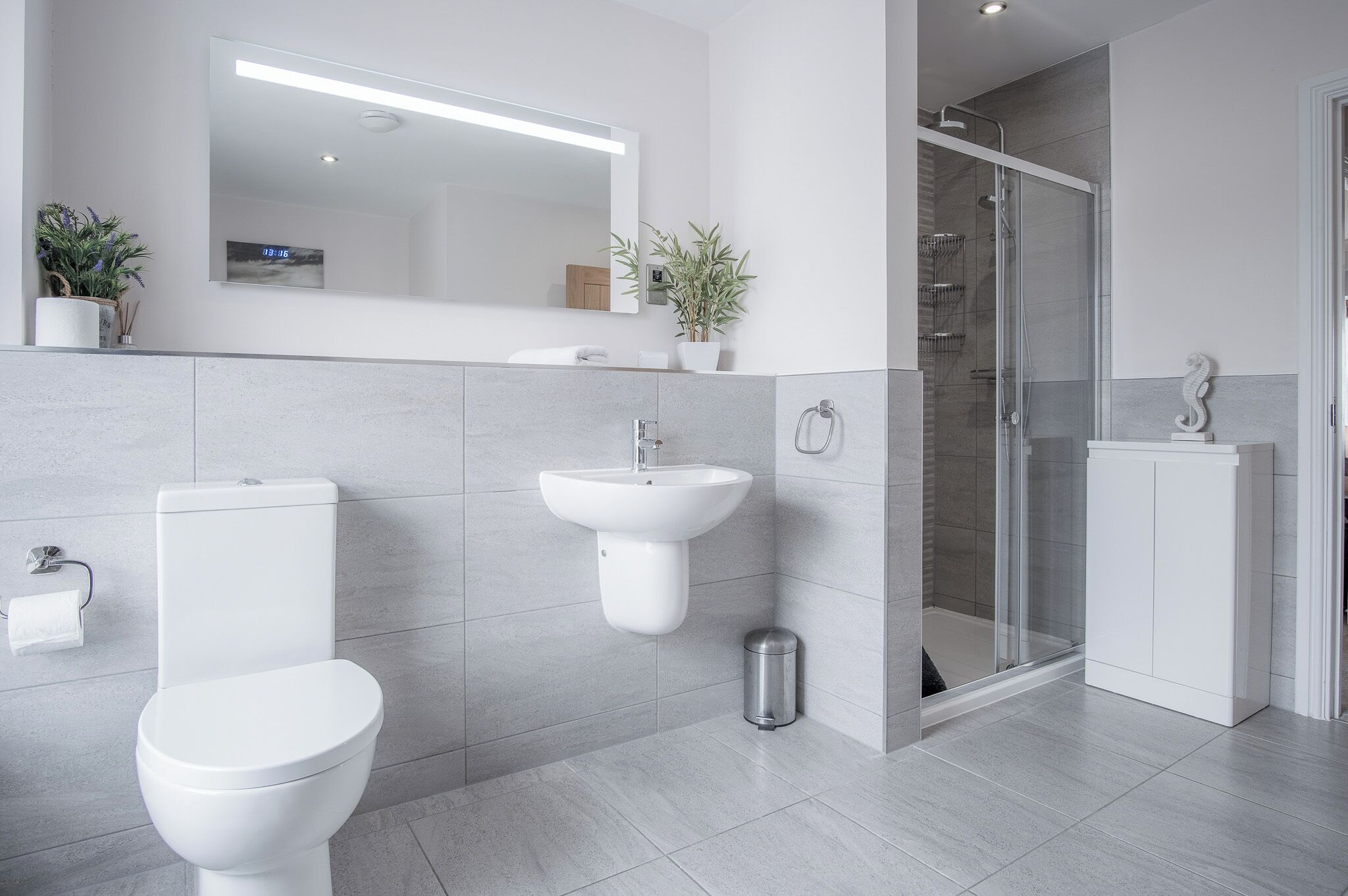 Une salle de bain moderne équipée de toilettes, d’un lavabo et d’une douche.