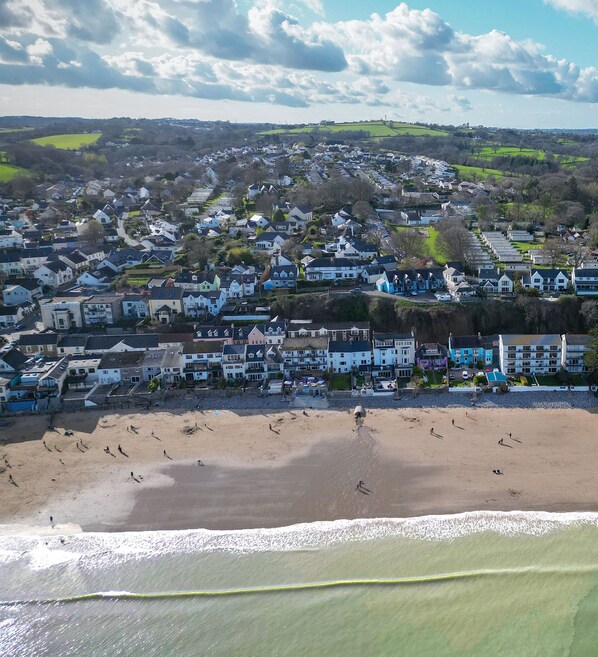 A coastal town with a beach, houses, and a mix of residential and commercial buildings.