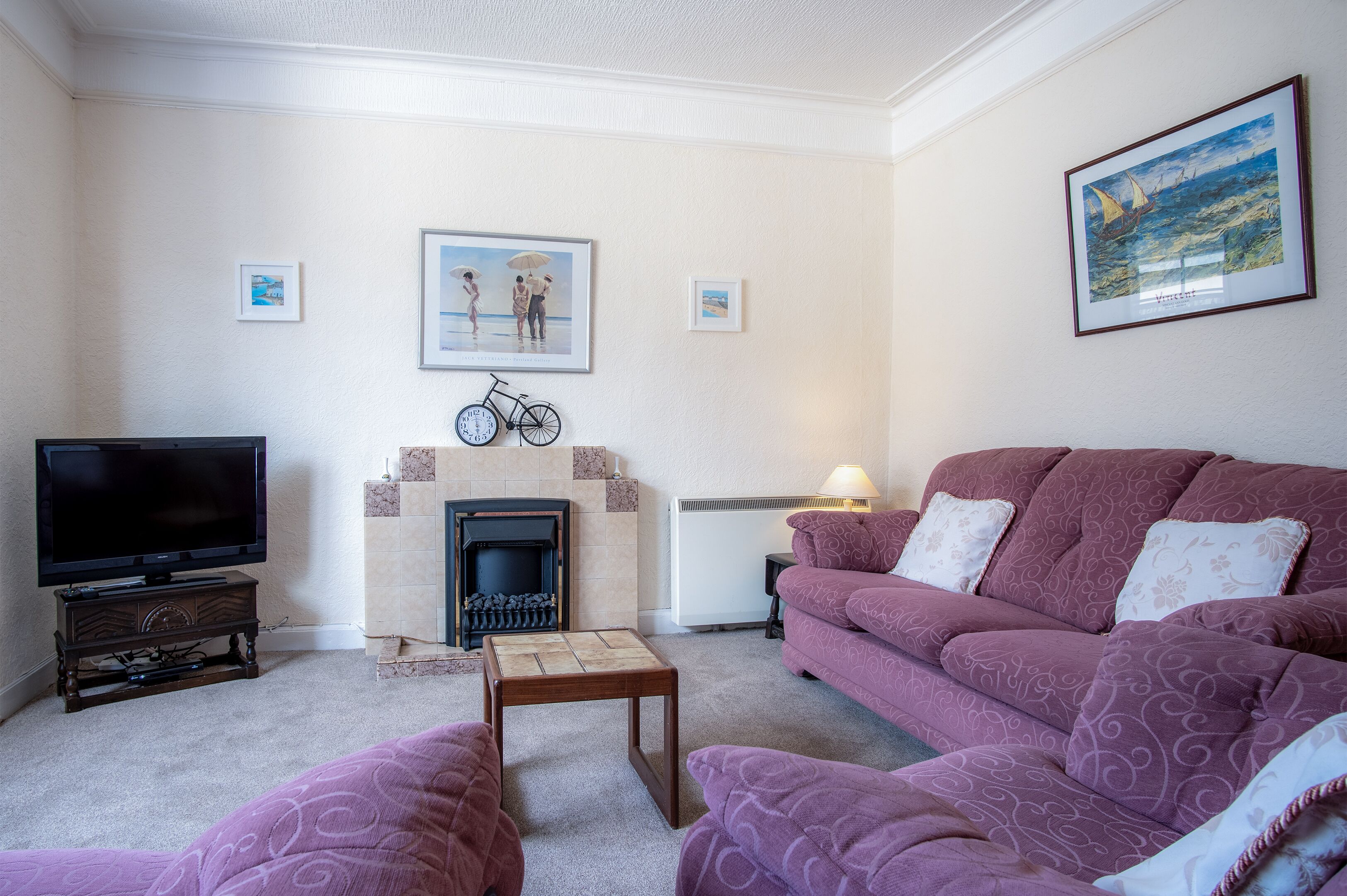 A living room with a television, a fireplace, a sofa, and a coffee table.
