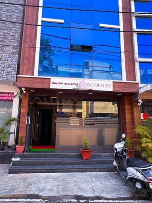 A hotel entrance with a sign reading "INTOURIST HOTEL". - Hotel InTourist by Agira Hotel (Bengaluru)