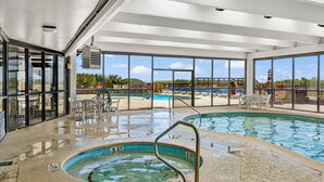 An indoor swimming pool with clear glass walls, a hot tub, and lounge chairs. - Welcome to WATER POINTE II, your ideal oceanfront escape in North Myrtle Beach (North Myrtle Beach)
