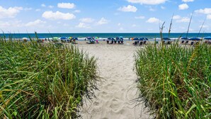 A beach path leading to a sandy beach with umbrellas and lounge chairs. - Welcome to WATER POINTE II, your ideal oceanfront escape in North Myrtle Beach (North Myrtle Beach)
