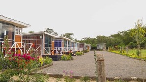 Una hilera de modernas casas móviles de un piso, con ventanas grandes, dispuestas en fila a lo largo de un camino de grava.